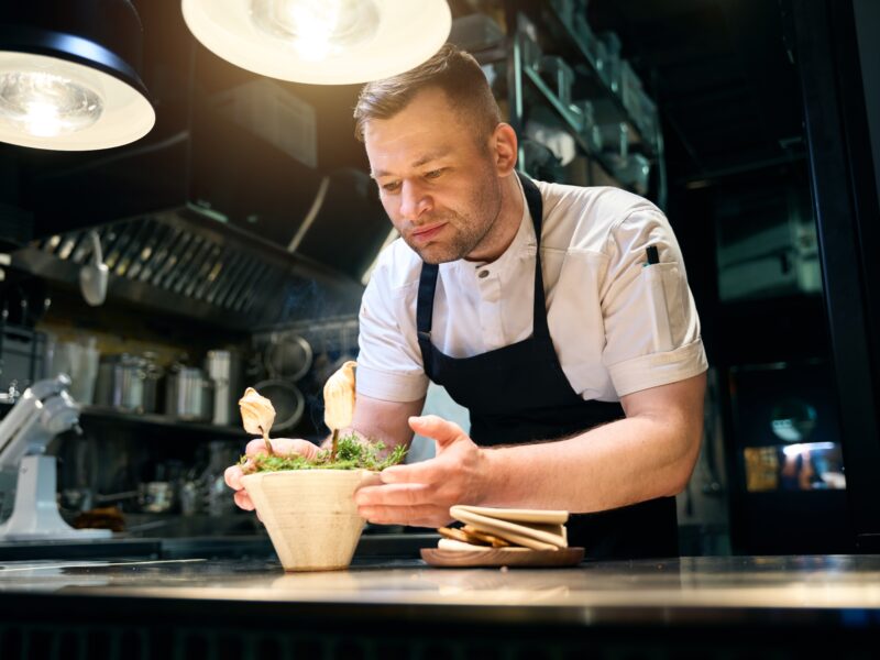 Concentrated,Man,Chef,Decorating,Marshmallows,On,Tree,Branches,In,Needles