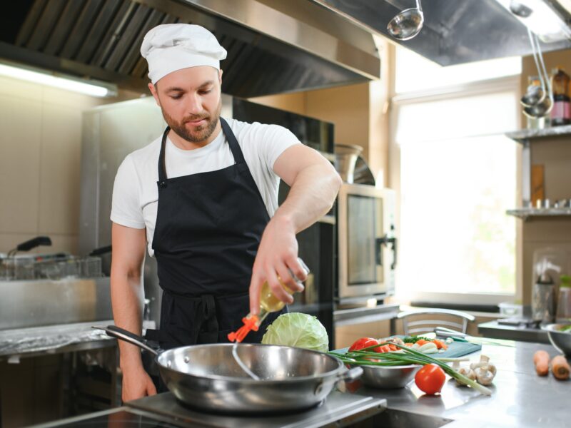Portrait,Of,Handsome,Positive,Chef,Cook,At,The,Restaurant,Kitchen.